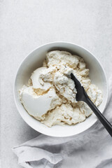 Strained Greek yogurt in a white ceramic bowl, process of making Greek yogurt, strained thick yogurt in white mixing bowl
