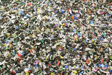 Close-up of shredded plastic pieces prepare for recycling. Raw cables material for reproduction....