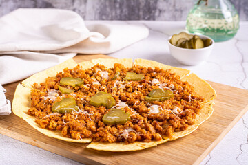 Smash burger tacos on tortilla with pickled cucumber and cheese on board