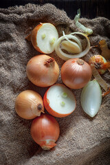 Ripe onion is a spicy product and vegetable. It is essential in the preparation of many delicious dishes. On an old background in a composition with kitchen accessories.