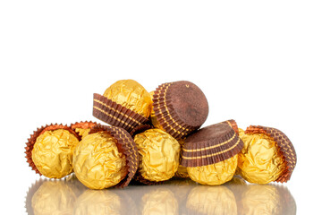 Several chocolate candies with a nut in a paper wrapper, macro, isolated on a white background.