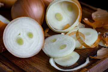 Ripe onion is a spicy product and vegetable. It is essential in the preparation of many delicious dishes. On an old background in a composition with kitchen accessories.