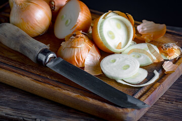 Ripe onion is a spicy product and vegetable. It is essential in the preparation of many delicious dishes. On an old background in a composition with kitchen accessories.