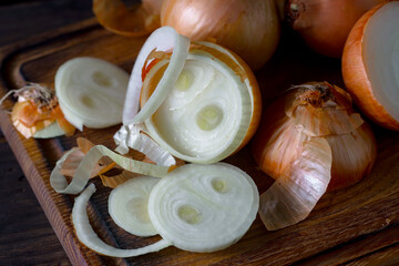 Ripe onion is a spicy product and vegetable. It is essential in the preparation of many delicious dishes. On an old background in a composition with kitchen accessories.