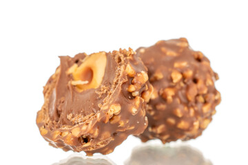 Two halves of a chocolate candy with a nut, macro, isolated on a white background.