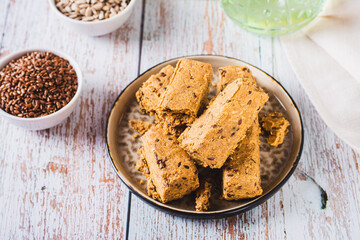 Pieces of halva with flax seeds on a plate on the table