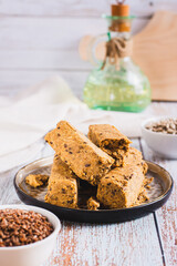 Sweet dessert halva from sunflower seeds with flax seeds on a plate vertical view