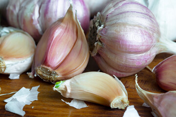 Garlic is a ripe, spicy product, a spice. It is essential in the preparation of many delicious dishes. On an old background in a composition with kitchen accessories.