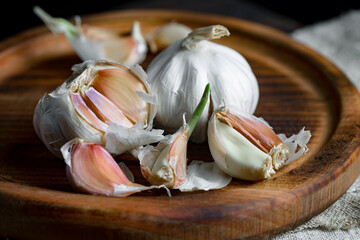 Garlic on a black background in the kitchen - a spicy vegetable