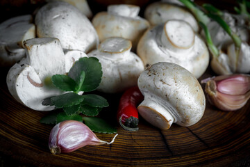 Champignon mushrooms in composition with food ingredients on old background