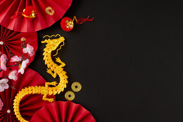 Wishing a joyful Chinese New Year 2024. Top view photo of gold dragon, paper fans, lucky coins,...