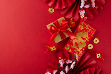 Gift suggestions for Chinese New Year festivities. Top view photo of red featuring fans, traditional envelope, gift box, sakura bloom, lucky coins on red background with promo zone - obrazy, fototapety, plakaty