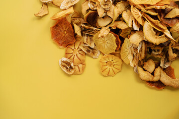Mound of fruit chips in the top corner on a yellow background