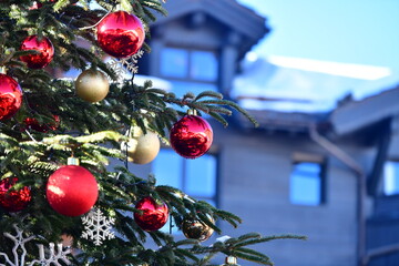 Decorated Christmas tree in front of a chalet 