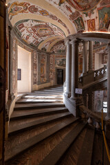 Caprarola, Viterbo, Italy - 2023, September 12: Palazzo Farnese, the principal staircase or Scala Regia, a graceful spiral of steps supported by pairs of Ionic columns. Frescoes by Antonio Tempesta. - obrazy, fototapety, plakaty