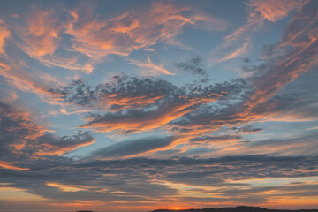 Showcase the dramatic line where the sky meets the land during sunset, depicting the merging of colors on the horizon.