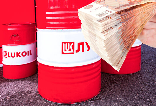 Branded Lukoil oil company barrels and russian rubles in the hand