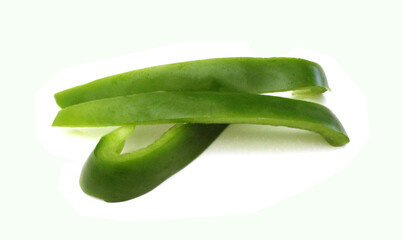 Sliced green bell pepper in a bowl on white background