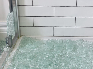 Broken glass shower door in a tiled bathroom