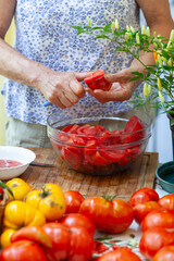 Cutting Fresh Beautiful Homegrown Organic Tomatoes on Domestic Table By a Senior Woman