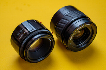 Camera lenses on a yellow background. Optical devices for image focusing.