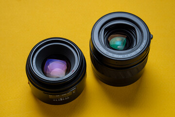 Camera lenses on a yellow background. Optical devices for image focusing.