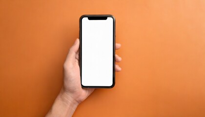 Fototapeta na wymiar Hand using smartphone with blank screen, isolated orange background 