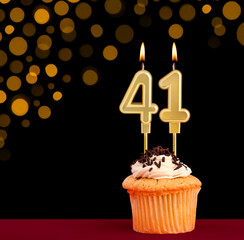 Birthday candle with cupcake - Number 41 on black background with out of focus lights
