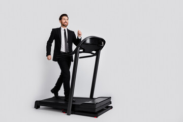 Full size profile photo of positive confident elegant person walk, treadmill empty space offer ad isolated on grey color background