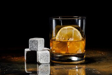 glass of whiskey with cooling stones. Dark gray bourbon stones.