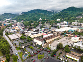 Naklejka premium city of Gatlinburg in Tennessee and the Great Smoky Mountains from a bird's eye view, a tourist mecca with hotels, parking and shops.