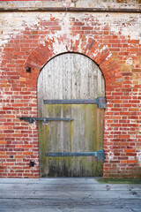 Fototapeta premium facade design. Close-up view of a wooden front door in a brick wall.