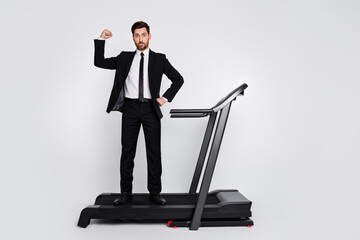 Full body photo of sportive classy person stand treadmill flexing biceps empty space advert isolated on grey color background