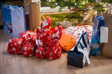 A bunch of christmas presents piled under a tree at this special day. Family gathering and presenting gifts.