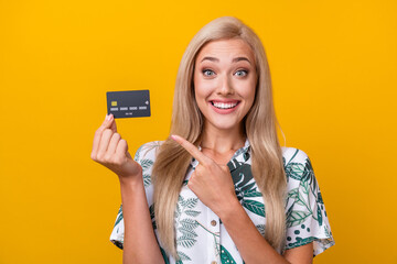 Photo of overjoyed impressed girl with long hair dressed print shirt indicating at credit card...