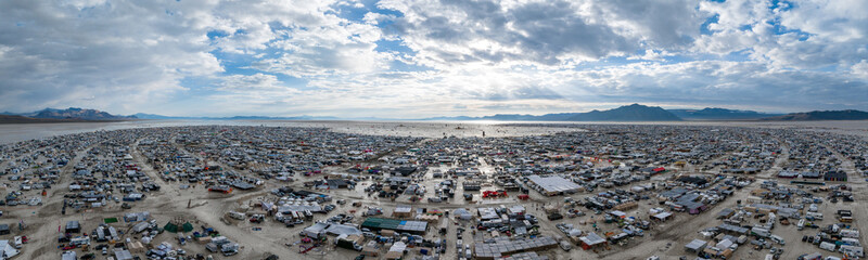 People camping in a desert during a heavy storm. Aerial shot of the camp city from above.