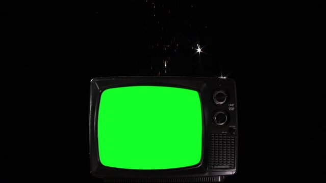 Old Television Turning On Green Screen Against Sky with Fireworks During New Year Celebrations. You can replace green screen with the footage or picture you want with “Keying” effect in After FXs.
