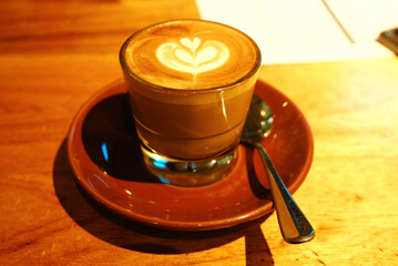 Selective focus with noise effect of coffee art on a cup of latte on the table