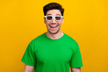 Photo of cheerful ecstatic man dressed green t-shirt 3d glasses watching excited movie having fun isolated on yellow color background