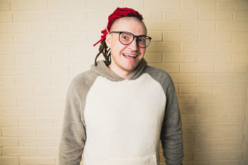 young attractive hipster man with red dreadlocks in glasses and a white sweater on the background...