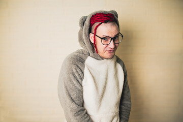 young attractive hipster man with red dreadlocks in glasses and a white sweater on the background...