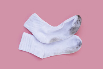 Dirty white socks on pink background.
