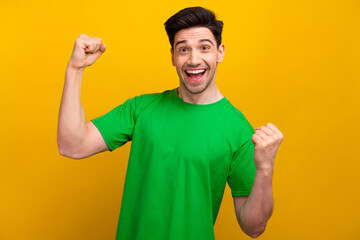 Photo of guy in green t shirt raise fists up he end internship finally gets promotion to junior...
