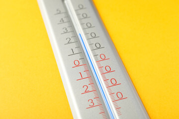 Modern weather thermometer on yellow background, closeup