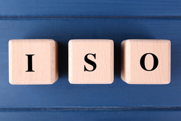 International Organization for Standardization. Cubes with abbreviation ISO on blue wooden table,...
