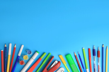 Fototapeta premium Flat lay composition with different school stationery on light blue background, space for text. Back to school