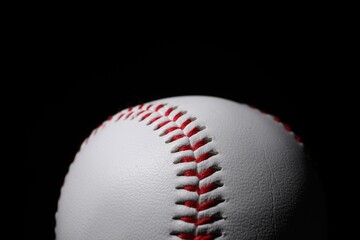 One baseball ball on black background, closeup