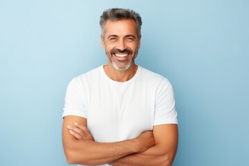 Handsome middle-aged man with white t-shirt on blue background - obrazy, fototapety, plakaty