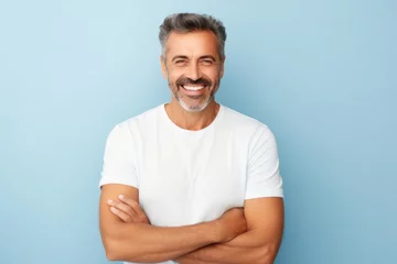 Foto op Plexiglas Handsome middle-aged man with white t-shirt on blue background © Inigo