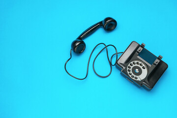 Top view of an antique telephone on a blue background.